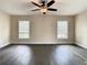 Spacious living room featuring two windows, a ceiling fan, and attractive dark wood flooring at 4209 W Woodlawn Ave, Tampa, FL 33614