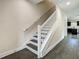 View of the staircase with white railing and dark wood steps in a well-lit home at 4209 W Woodlawn Ave, Tampa, FL 33614