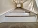 A close-up view of the stairway with white risers and dark wood treads leading to the upper level at 4209 W Woodlawn Ave, Tampa, FL 33614