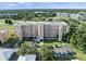 Expansive aerial view of the condo building, showcasing its landscaping, parking, and proximity to golf course at 4410 Fairways Blvd # 104, Bradenton, FL 34209
