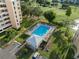 Aerial view of condo community with refreshing pool area, mature trees, and adjacent golf course at 4410 Fairways Blvd # 104, Bradenton, FL 34209