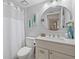 Clean bathroom with a round mirror, white vanity, and shower with curtain at 4410 Fairways Blvd # 104, Bradenton, FL 34209