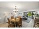 Open-concept dining area with seating for four, chandelier, and view of the living room at 4410 Fairways Blvd # 104, Bradenton, FL 34209