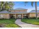 Community center exterior featuring manicured landscape, brick paver sidewalk, and covered entryway at 4410 Fairways Blvd # 104, Bradenton, FL 34209