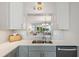 Modern kitchen featuring stainless steel sink, white countertops, tile backsplash, and updated cabinets at 4410 Fairways Blvd # 104, Bradenton, FL 34209