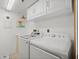 Well-lit laundry room equipped with a washing machine and dryer, plus overhead storage at 4410 Fairways Blvd # 104, Bradenton, FL 34209