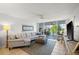 Spacious living room with sectional sofa and access to the outdoor balcony at 4410 Fairways Blvd # 104, Bradenton, FL 34209
