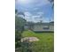 Side view of the backyard with manicured lawn, privacy fence, and a bricked area, ideal for gardening at 48 Dade Ave, Sarasota, FL 34232