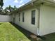 This exterior shot shows a light colored home with black framed windows and a well-maintained yard at 48 Dade Ave, Sarasota, FL 34232