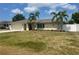Charming single-story home featuring a well-maintained lawn, palm trees, and a two-car garage at 48 Dade Ave, Sarasota, FL 34232