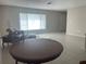 Open-concept living area with tiled floors, large window, and a dining table, ideal for gatherings at 48 Dade Ave, Sarasota, FL 34232