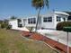 Charming single-story home featuring a palm tree, green lawn, and landscaped garden beds at 5118 Oakland Hills Ave, Sarasota, FL 34234