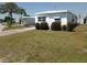 Charming home exterior with green lawn and mature landscaping at 5118 Oakland Hills Ave, Sarasota, FL 34234