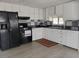 Well-equipped kitchen with white cabinets, black appliances, and a checkerboard backsplash at 5118 Oakland Hills Ave, Sarasota, FL 34234