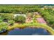 Aerial view of the community amenities including the pool, playground, tennis courts, and basketball court overlooking the pond at 518 Chantilly Trl, Bradenton, FL 34212