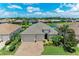 Stunning aerial view of a home featuring a three-car garage, lush landscaping, and a picturesque lake view at 518 Chantilly Trl, Bradenton, FL 34212