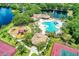 Beautiful aerial view of community pool, playground, tennis courts, and clubhouse with water views at 518 Chantilly Trl, Bradenton, FL 34212