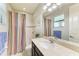 Bathroom features a single vanity, a tile shower with a striped shower curtain, and a toilet at 518 Chantilly Trl, Bradenton, FL 34212