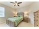 Bedroom features a wooden bed frame and matching furniture, a ceiling fan, and two windows at 518 Chantilly Trl, Bradenton, FL 34212