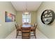 Dining room with a wood table, modern light fixture, and natural light from the window at 518 Chantilly Trl, Bradenton, FL 34212