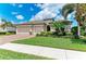 Beautifully landscaped single-Gathering home featuring a three-car garage, manicured lawn, and lush tropical landscaping at 518 Chantilly Trl, Bradenton, FL 34212