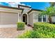 Inviting entryway of home with a manicured garden and stone-paved driveway at 518 Chantilly Trl, Bradenton, FL 34212