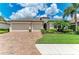 Charming home with a well-manicured lawn, mature landscaping, and a brick paved driveway at 518 Chantilly Trl, Bradenton, FL 34212