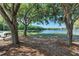 Peaceful lakeside view with mature trees providing shade and a bench for relaxation; a perfect spot to unwind and enjoy nature at 518 Chantilly Trl, Bradenton, FL 34212