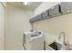 Laundry room with a washer, dryer, utility sink and storage baskets on a shelf at 518 Chantilly Trl, Bradenton, FL 34212