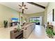 Open living room with vaulted ceilings, ceiling fan, and sliding glass doors to the backyard at 518 Chantilly Trl, Bradenton, FL 34212