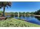 Scenic view of a tranquil pond with a fountain, surrounded by lush greenery and trees, creating a serene atmosphere at 518 Chantilly Trl, Bradenton, FL 34212