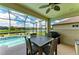 Screened-in lanai featuring an outdoor dining table and pool with a canal view at 518 Chantilly Trl, Bradenton, FL 34212