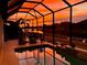 Relaxing screened-in pool with a stunning orange sunset view over the lake at 518 Chantilly Trl, Bradenton, FL 34212
