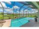 Inviting screened-in pool with a relaxing waterfall feature and scenic view of the lake at 518 Chantilly Trl, Bradenton, FL 34212