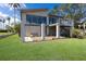 Spacious backyard featuring an outdoor deck, lush green lawn, and a full wall of sliding glass at 5912 Riverview Ln, Bradenton, FL 34209