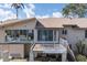 Exterior rear view of home features a deck, stairs to the yard, and large windows with great natural light at 5912 Riverview Ln, Bradenton, FL 34209