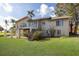 Exterior rear view of home features a deck, stairs to the yard, and large windows for natural light at 5912 Riverview Ln, Bradenton, FL 34209