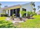 Backyard view showcasing the property's exterior, screened lanai, and tropical landscaping at 6222 Country Club Way, Sarasota, FL 34243