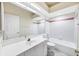 Bright bathroom with white tiles, spacious vanity, and combination tub and shower at 6222 Country Club Way, Sarasota, FL 34243