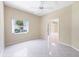 Bedroom features tile flooring, a ceiling fan, and large window for natural light at 6222 Country Club Way, Sarasota, FL 34243