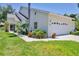 Charming home featuring a two-car garage, well-maintained lawn, and lush tropical landscaping at 6222 Country Club Way, Sarasota, FL 34243