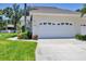 Garage exterior with white door, tropical plants in landscaping, and clear driveway at 6222 Country Club Way, Sarasota, FL 34243