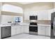 Kitchen with stainless steel appliances and white cabinets at 6222 Country Club Way, Sarasota, FL 34243