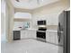 Kitchen with stainless steel appliances, white cabinets and tile flooring at 6222 Country Club Way, Sarasota, FL 34243