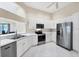 Kitchen with stainless steel appliances, white cabinetry, open arch, and view to the outside at 6222 Country Club Way, Sarasota, FL 34243