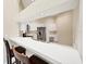 Modern kitchen with white cabinets, bar seating, stainless steel appliances, and desk area at 6222 Country Club Way, Sarasota, FL 34243