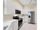 Bright kitchen featuring stainless steel appliances, white cabinetry, and ample counter space at 6222 Country Club Way, Sarasota, FL 34243