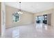 Bright open living room with access to the outdoors and elegant chandelier at 6222 Country Club Way, Sarasota, FL 34243
