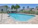 Inviting community pool with brick paver deck, surrounded by lush tropical landscaping, and comfortable lounge chairs at 6222 Country Club Way, Sarasota, FL 34243