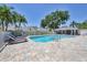 Inviting community pool with brick paver deck, screened in gazebo, surrounded by lush tropical landscaping, and comfortable lounge chairs at 6222 Country Club Way, Sarasota, FL 34243